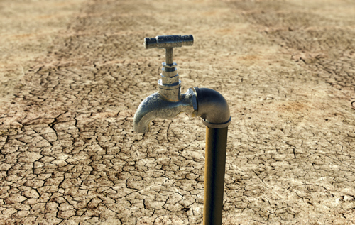 tap water and ground is covered with cracks due to drought